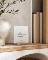 A Hope That Will Never Disappoint 4x4 Christian shelf sitter with natural wood base, styled in a organic modern built-in shelf scene.