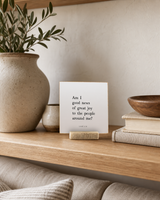 Am I Good News of Great Joy 4x4 Christian shelf sitter with natural wood base, styled in a family room floating shelf scene.