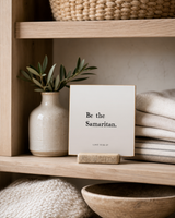 Be the Samaritan 4x4 Christian shelf sitter with natural wood base, styled in a linen cabinet shelf scene.