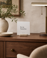 Be the Samaritan 4x4 Christian shelf sitter with natural wood base, styled in a quiet home office credenza scene.