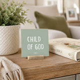 “Child of God” 4 x 4-inch shelf sitter in the white lettering on green finish, displayed in a family prayer corner.