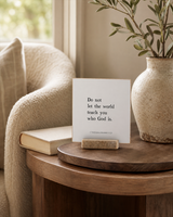 Do Not Let the World Teach You Who God Is 4x4 Christian shelf sitter with natural wood base, styled in a reading chair side table scene.