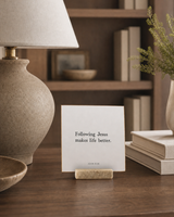 Following Jesus Makes Life Better 4x4 Christian shelf sitter with natural wood base, styled in a library writing desk scene.