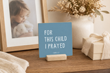 “For This Child I Prayed,” a 4 x 4-inch shelf sitter in the white lettering on blue finish, styled on an adoption celebration console.
