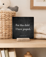 For This Child I Have Prayed 4x4 Christian Shelf Sitter on a nursery shelf with a woven basket and folded baby textiles.