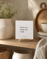 Future Joy Brings Joy Today 4x4 Christian shelf sitter with natural wood base, styled in a cottage kitchen open shelf scene.