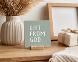 “Gift from God,” a 4 x 4-inch shelf sitter in the white text on green finish, styled on an adoption celebration console.