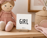 Girl,” a 4 x 4-inch shelf sitter in the black lettering on white distressed finish, styled in a doll corner.