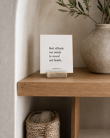 God Offends Our Minds to Reveal Our Hearts 4x4 Christian shelf sitter with natural wood base, styled in a organic modern built-in shelf scene.