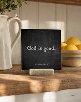 God Is Good 4x4 Christian Shelf Sitter on a warm kitchen surface with a white pitcher, bowl of lemons, and leafy greenery.
