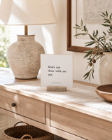 God's Not Done With Me Yet 4x4 Christian shelf sitter with natural wood base, styled in a sunlit white oak entry console scene.