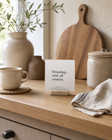 Groaning With All Creation 4x4 Christian shelf sitter with natural wood base, styled in a modern farmhouse kitchen nook scene.