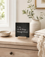 I Can Do All Things Through Christ 4x4 Christian Shelf Sitter on a light dresser by a window with a white vase and folded textiles.