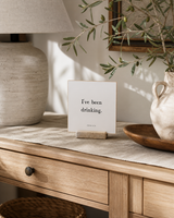 I've Been Drinking 4x4 Christian shelf sitter with natural wood base, styled in a sunlit white oak entry console scene.