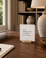 In the Kingdom of God Your Opinion Does Not Count 4x4 Christian shelf sitter with natural wood base, styled in a library writing desk scene.