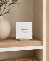 It's Gonna Be Okay 4x4 Christian shelf sitter with natural wood base, styled in a organic modern built-in shelf scene.
