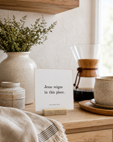 Jesus Reigns in This Place 4x4 Christian shelf sitter with natural wood base, styled in a modern farmhouse kitchen nook scene.