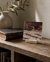 Jesus Died For Me 4x4 Christian Shelf Sitter with sepia artwork on a rustic wood shelf beside pottery and a closed vintage book.