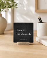 Jesus Is the Standard 4x4 Christian Shelf Sitter on a light desk with a ceramic pencil cup, neutral books, and greenery.