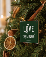 Dark Green 4x4 Love Came Down ornament with metal wire hanger on a farmhouse tree with dried orange and velvet ribbon.
