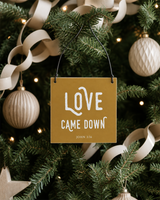 Gold 4x4 Love Came Down ornament with metal wire hanger on a modern farmhouse tree with cream paper chains and pale wood ornaments.
