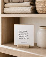 Many People Don't Believe in the Jesus Story 4x4 Christian shelf sitter with natural wood base, styled in a linen cabinet shelf scene.