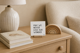 “May We Never Lose Our Wonder,” a 4 x 4-inch shelf sitter in the black lettering on white distressed finish, styled on a neutral nursery dresser.