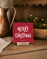 Red 4x4 Merry Christmas Christmas Shelf Sitter in a kitchen hutch with copper with its rustic wood slot stand.
