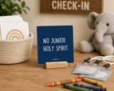 Close-up of “No Junior Holy Spirit,” a 4 x 4-inch shelf sitter in the white lettering on dark blue finish in a sunday school check-in.