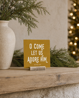Gold 4x4 O Come Let Us Adore Him Christmas Shelf Sitter in a organic modern christmas mantel with its rustic wood slot stand.