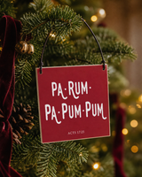 Red 4x4 Pa-Rum-Pa-Pum-Pum ornament with metal wire hanger on a green tree with brass bells and burgundy velvet ribbon.