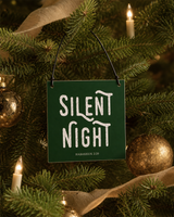 Dark Green 4x4 Silent Night ornament with metal wire hanger on a classic fir with candle lights, aged gold balls, and cream linen ribbon.