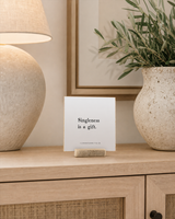 Singleness Is a Gift 4x4 Christian shelf sitter with natural wood base, styled in a apartment sideboard scene.
