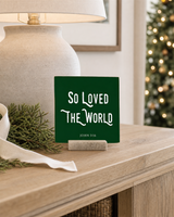 Dark Green 4x4 So Loved the World Christmas Shelf Sitter in a quiet hallway console with its rustic wood slot stand.