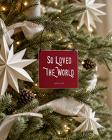Red 4x4 So Loved the World ornament with metal wire hanger on an organic-modern tree with ivory paper stars and linen ribbon.