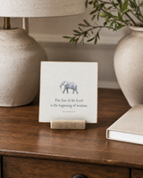 The Fear of the Lord Is the Beginning of Wisdom elephant Scripture shelf sitter with Proverbs 9:10, styled in the library writing desk scene.