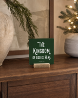Dark Green 4x4 The Kingdom of God Is Here Christmas Shelf Sitter in a formal study console without books with its rustic wood slot stand.