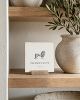 The King Is Alive lion Scripture shelf sitter with Luke 24:6, styled in the timeless living room built-in scene.