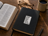 Close-up of “The Man on the Middle Cross Told Me I Can Come,” a faith sticker displayed on the cover of a prayer journal.