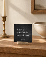 There Is Power in the Name of Jesus 4x4 Christian Shelf Sitter on a rustic table with a brass candlestick and neutral stoneware.