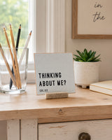 Thinking About Me 4x4 Christian Shelf Sitter on a writing desk with pencils, a small plant, and neutral stacked books.