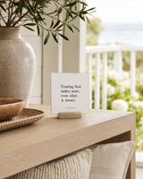 Trusting God Makes Sense 4x4 Christian shelf sitter with natural wood base, styled in a covered porch console scene.