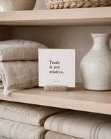 Truth Is Not Relative 4x4 Christian shelf sitter with natural wood base, styled in a linen cabinet shelf scene.