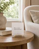 When You Pray, What Does God Get 4x4 Christian shelf sitter with natural wood base, styled in a reading chair side table scene.